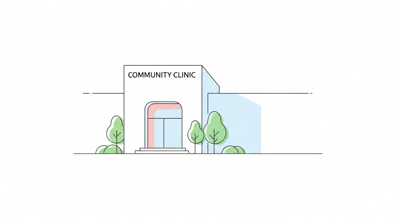 Bangunan hadapan Klinik Komuniti yang bersih dan moden dengan sedikit kehijauan di sekitarnya.