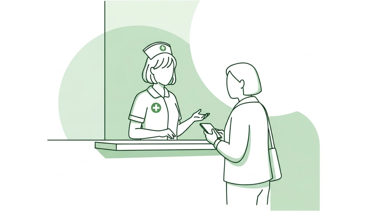 Seorang jururawat sedang membantu seorang pengunjung di kaunter maklumat hospital.